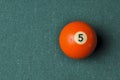 Old billiard ball number 5 orange color on green billiard table, copy space Royalty Free Stock Photo