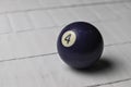 Old billiard ball number 4 purple color on white wooden table background, copy space Royalty Free Stock Photo