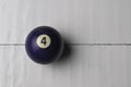 Old billiard ball number 4 purple color on white wooden table background, copy space Royalty Free Stock Photo