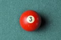 Old billiard ball number 3 red color on green billiard table, copy space Royalty Free Stock Photo