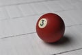 Old billiard ball number 3 red color on white wooden table background, copy space Royalty Free Stock Photo