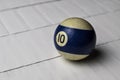 Old billiard ball number 10 striped white and blue on white wooden table background, copy space Royalty Free Stock Photo