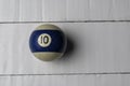 Old billiard ball number 10 striped white and blue on white wooden table background, copy space Royalty Free Stock Photo