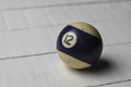 Old billiard ball number 12 striped white and purple on white wooden table background, copy space Royalty Free Stock Photo