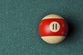 Old billiard ball number 11 striped white and red on green billiard table, copy space Royalty Free Stock Photo