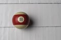 Old billiard ball number 11 striped white and red on white wooden table background, copy space Royalty Free Stock Photo