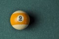 Old billiard ball number 9 striped white and yellow on green billiard table, copy space Royalty Free Stock Photo