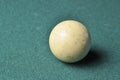 Old billiard ball white color on green billiard table, copy space