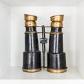 Old binoculars on white shelf Royalty Free Stock Photo