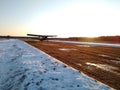 Old biplane plane on takeoff after taking off from the runway rear view of a winter landscape at sunset Royalty Free Stock Photo