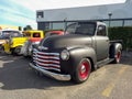 Old black 1947 Chevrolet Thriftmaster pickup truck Advance Design in a parking lot.