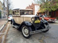Old black and cream 1930s Ford Model A Tudor sedan parked in the