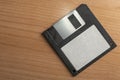 Old 3.5 black floppy disk with blank label on a wooden table Royalty Free Stock Photo