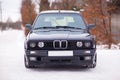 Old, black, German family car front view in winter