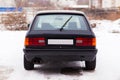 Old, black, German family car rear view in winter