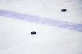 Old , black ice hockey puck near blue line in ice hockey rink Royalty Free Stock Photo