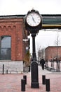 Old black iron hall clock at the Distillery District and many red buildings in Toronto, Canada