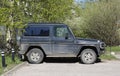 An old black jeep is parked near the lawn