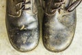 Old black leather shoes on the floor. Pair of old dirty black leather shoes Royalty Free Stock Photo