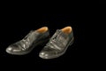 Old black men dusty leather shoes isolated on black background, unemployment concept Royalty Free Stock Photo