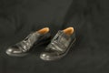 Old black men dusty leather shoes isolated on black background, unemployment concept Royalty Free Stock Photo