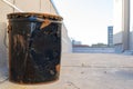 Old, black metal bucket, dented & rusty, on a New York City rooftop, Bronx, NY