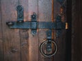 Old black metal deadbolt on a wooden door