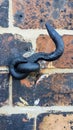 Old Black Metal Hook on a Brick Wall