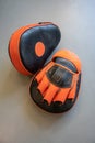 Old black and orange boxing gloves on grey concrete background Royalty Free Stock Photo