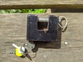 old and black padlock with keys on a wooden background Royalty Free Stock Photo