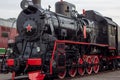 Old black and red retro steam locomotive at the railway station. Vintage train staying on the railroad. Royalty Free Stock Photo