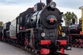 Old black and red retro steam locomotive at the railway station. Vintage train staying on the railroad. Royalty Free Stock Photo