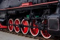 Old black and red retro steam locomotive wheels at the railway station. Vintage train staying on the railroad. Royalty Free Stock Photo