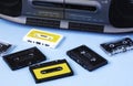 Old black retro cassette music audio tape recorder and retro cassette tape collection on blue background Royalty Free Stock Photo