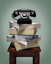 Old black rotary dial telephone on stack of phone books Royalty Free Stock Photo