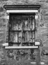 Old black shuttered window set in a cracked wall Royalty Free Stock Photo