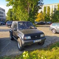 Old black small 4WD Suzuki Jimny parked