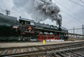 Old black steam engine with tender belching out steam Royalty Free Stock Photo