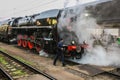 Old black steam engine with tender standing at train station Royalty Free Stock Photo