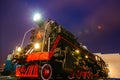 Old black steam locomotive on railway station at night