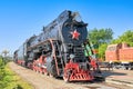 An old black steam locomotive with a red star in front