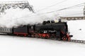Old black steam locomotive in Russia in the winter on a background of bridge Royalty Free Stock Photo