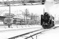 Old black steam locomotive in Russia in the winter on the background of modern electric trains Royalty Free Stock Photo