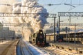 Old black steam locomotive in Russia in the winter on the background of the Moscow railway station Royalty Free Stock Photo