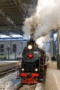 Old black steam locomotive in Russia in the winter on the background of the Moscow railway station Royalty Free Stock Photo