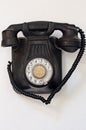 Old black telephone hanging on a white wall Royalty Free Stock Photo