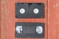 Old black VHS video tipe cassette on the red wooden floor Royalty Free Stock Photo