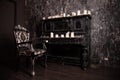 Old black vintage piano with white candles and retro chair. nobody Royalty Free Stock Photo