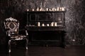 Old black vintage piano with white candles and retro chair. nobody Royalty Free Stock Photo