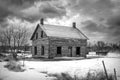 Old black and white abandoned spooky looking farmhouse in winter on a farm yard in rural Canada Royalty Free Stock Photo